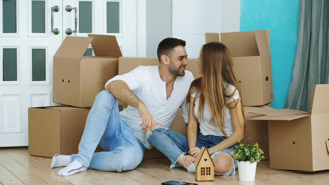 New homeowners carrying moving boxes into their house on completion day
