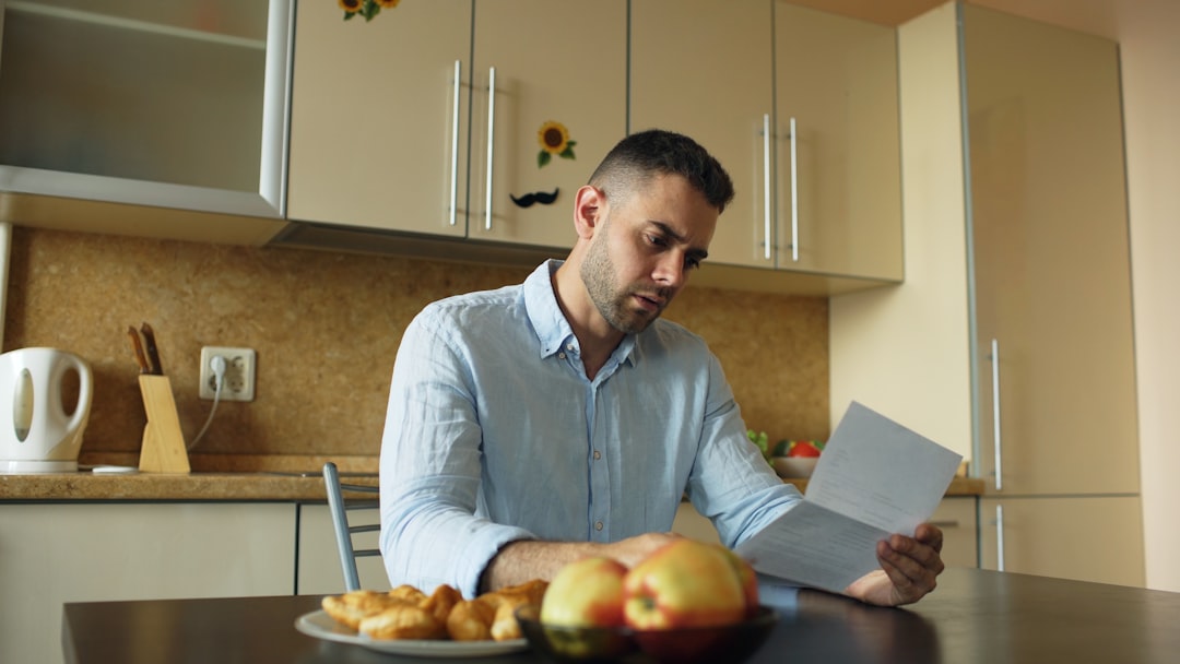 A buyer carefully reading a property survey report at a kitchen table