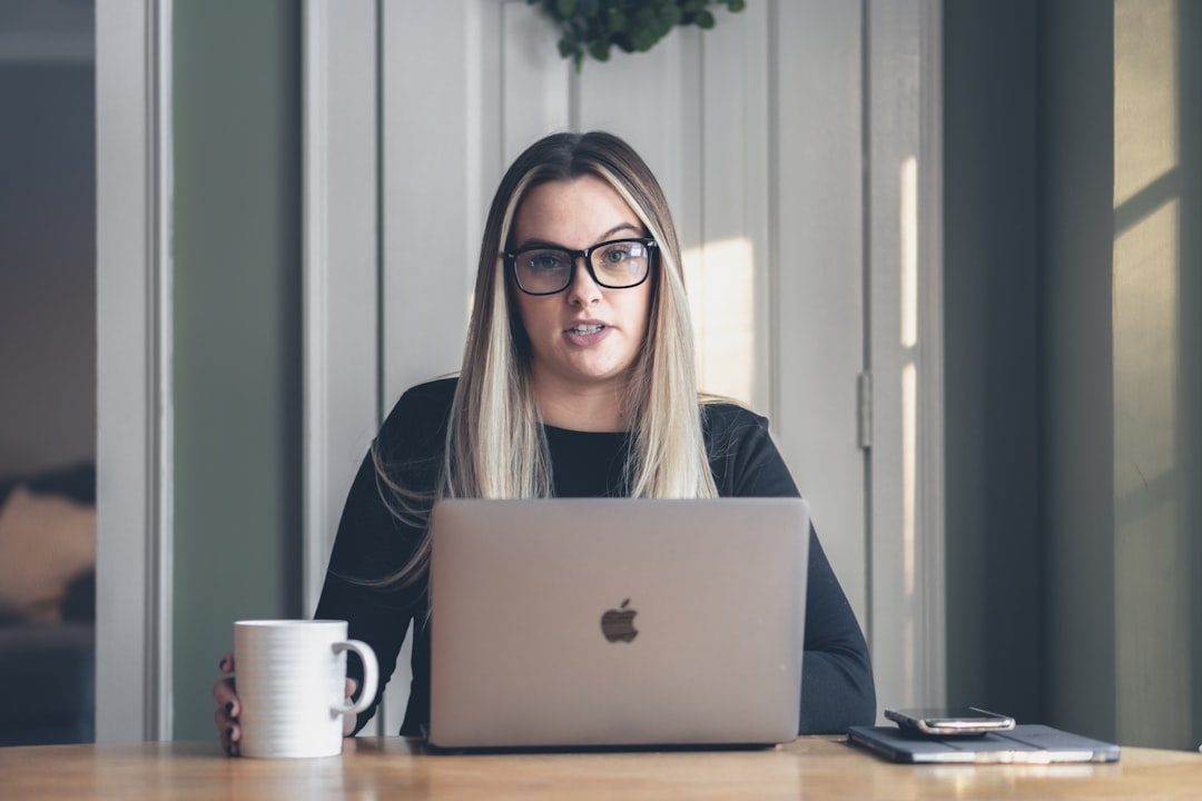 Home buyer at a bright kitchen table composing a chasing email to her conveyancing solicitor