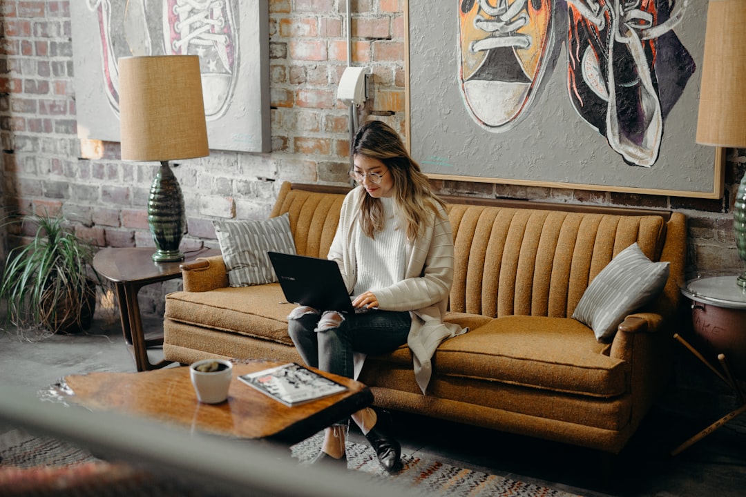 Home buyer at a kitchen table writing a chasing email to her solicitor on a laptop