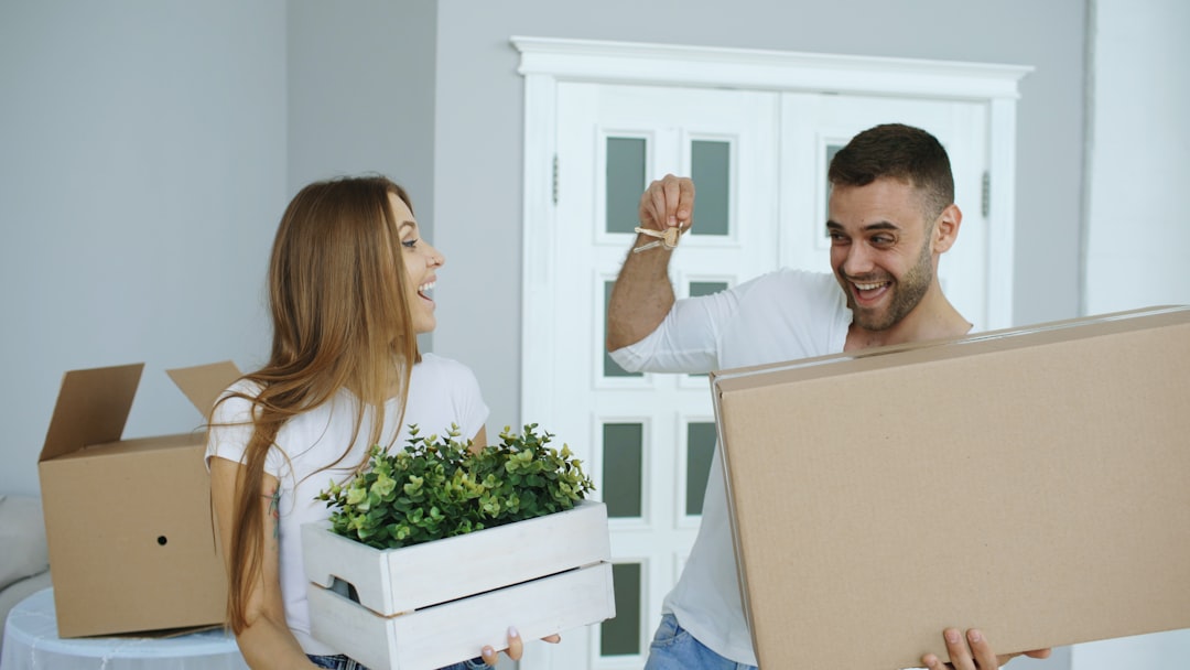 Couple outside a UK terraced house making a checklist after having their offer accepted
