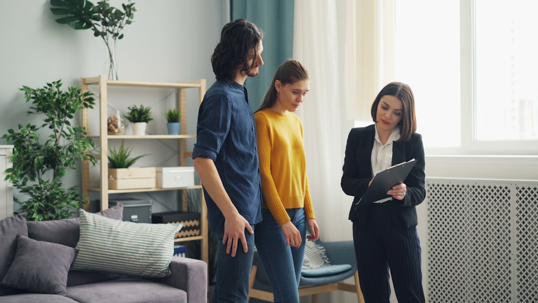 Buyers asking an estate agent questions outside a UK terraced house before making an offer