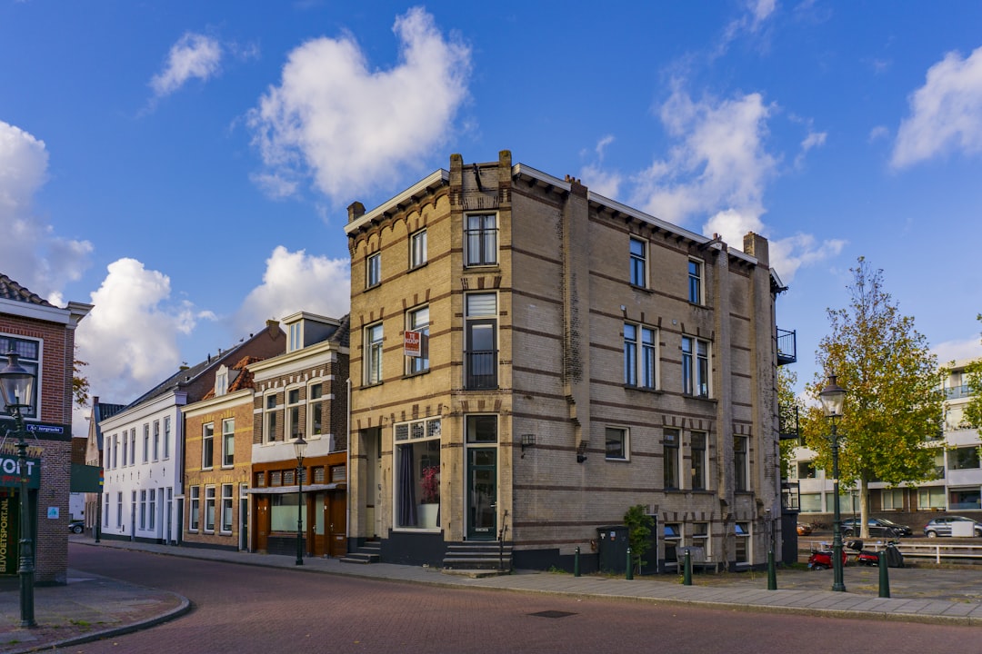 Buyer asking an estate agent how long the property has been on the market outside a UK terraced house